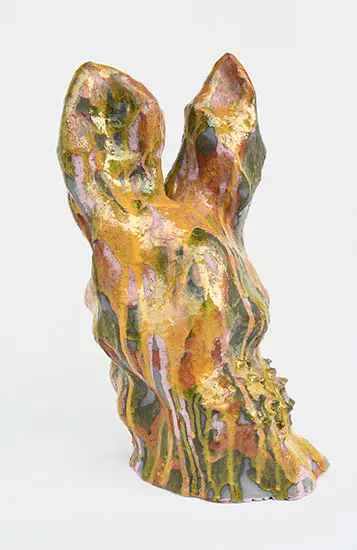 Skulptur som ser ut som en liten kanin med rennende glasur i oker og hvitt